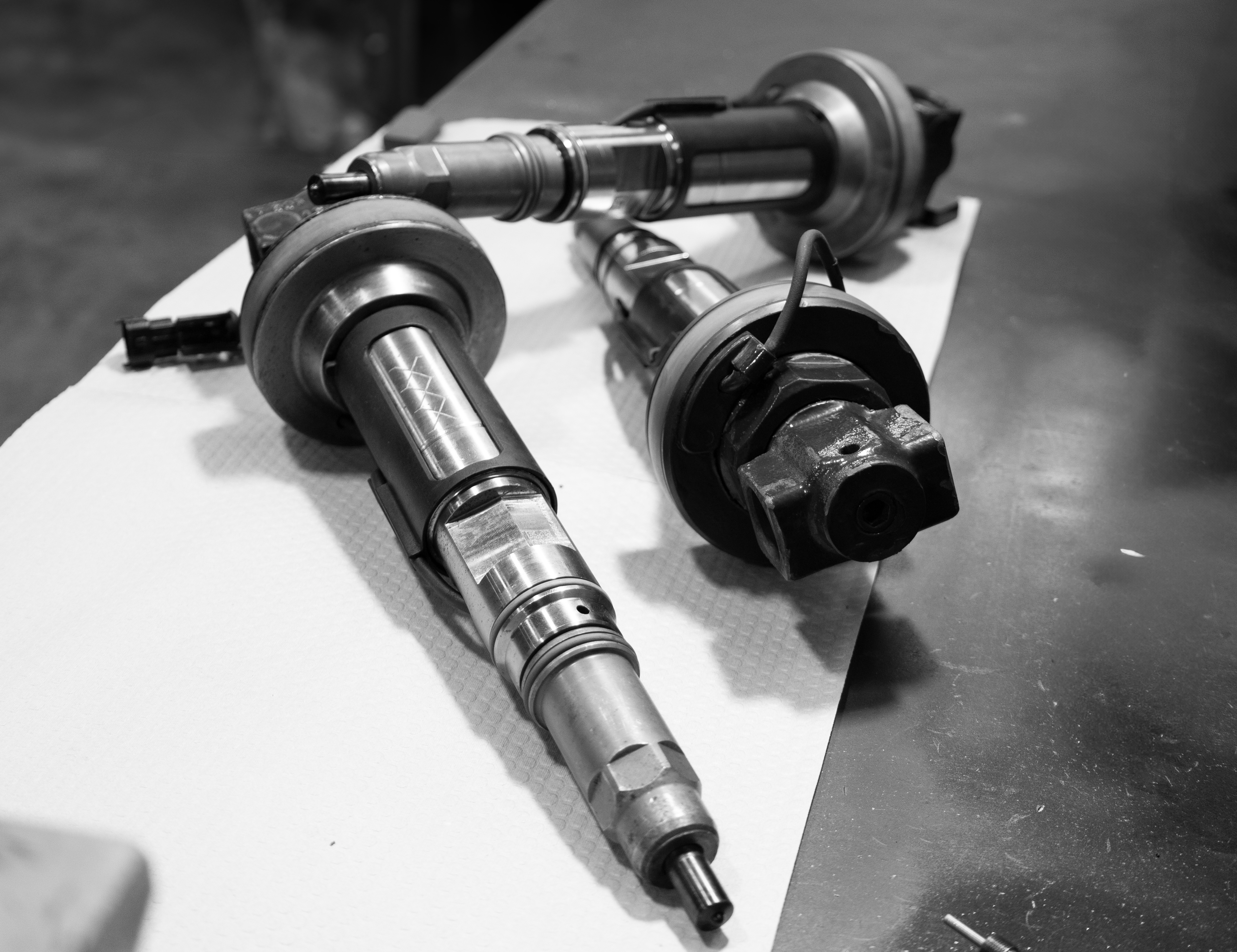 Heavy duty diesel injectors on a workshop table.