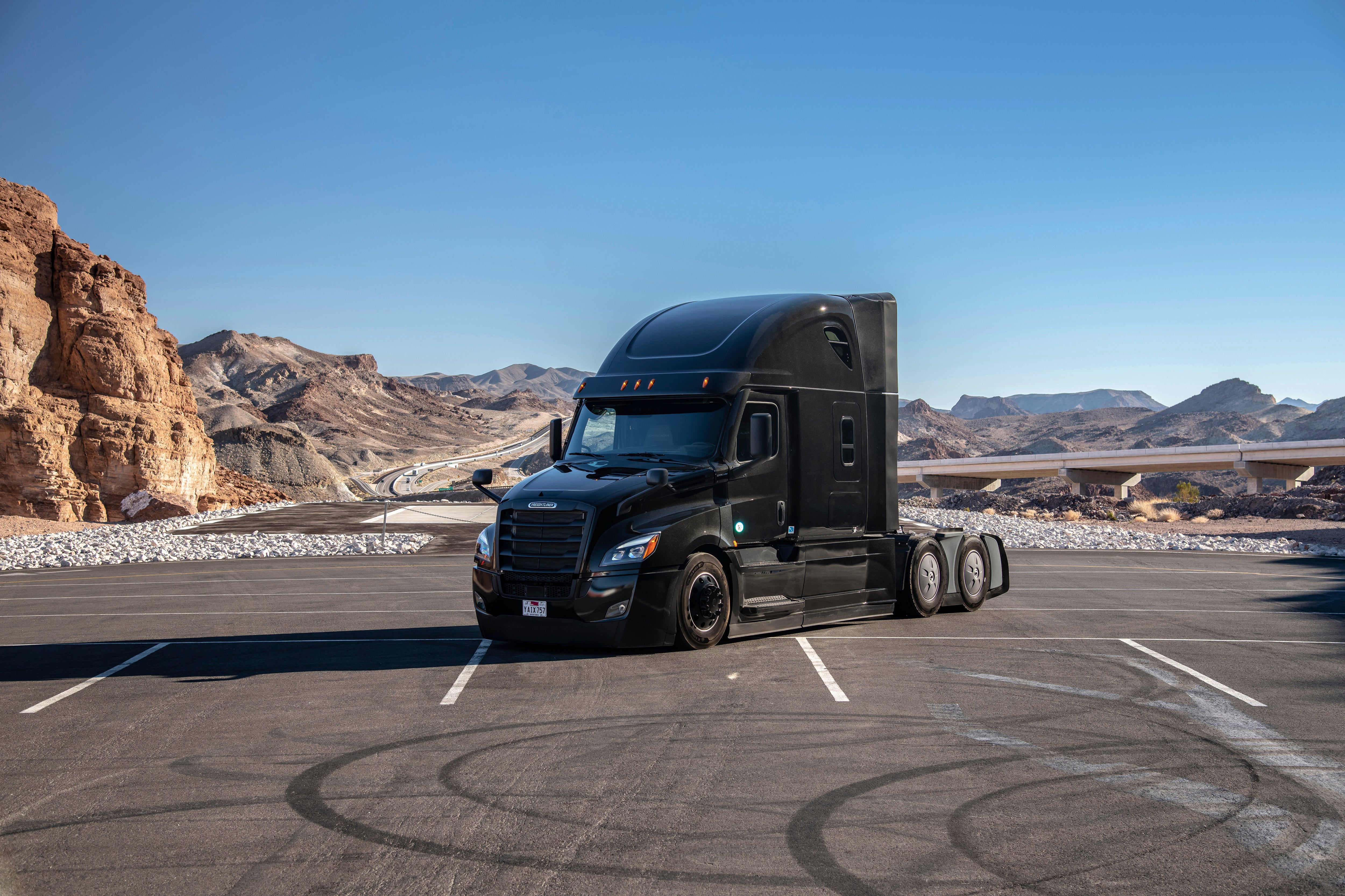 Black heavy duty truck in a scenic desert landscape.